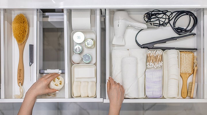 an organized bathroom drawer using bins and dividers